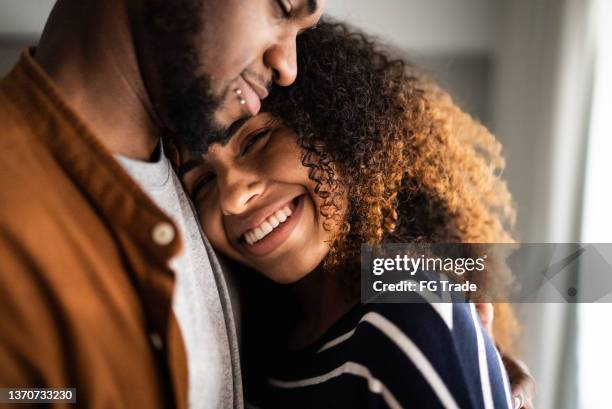 portrait of a young woman leaning on husband's chest at home - woman flat chest 個照片及圖片檔