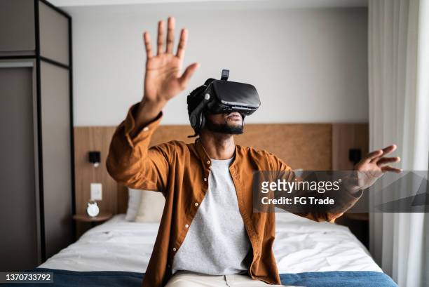young man using a virtual reality glasses at home - computer gaming stock pictures, royalty-free photos & images