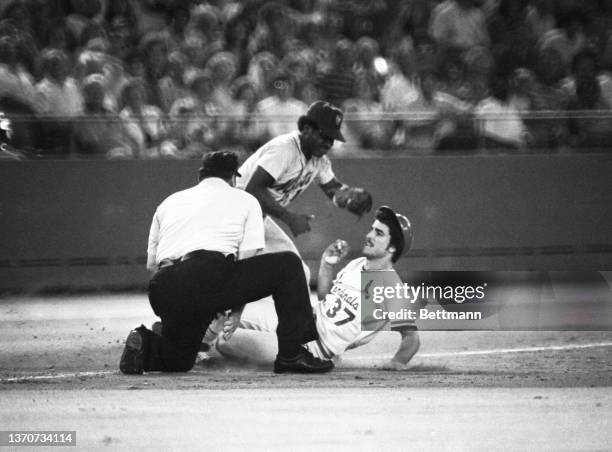 New York Mets' Lenndle Randle tumbles over umpire Harry Wendelstedt after tagging out St. Louis Cardinals' Keith Hernandez as he tried for a triple...