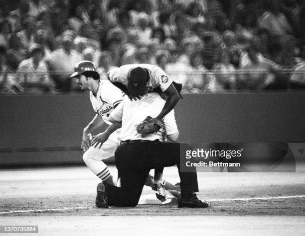 New York Mets' Lenndle Randle tumbles over umpire Harry Wendelstedt after tagging out St. Louis Cardinals' Keith Hernandez as he tried for a triple...