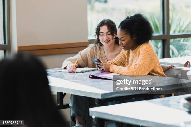 teen girls take break to mess with phone - learn arabic stock pictures, royalty-free photos & images