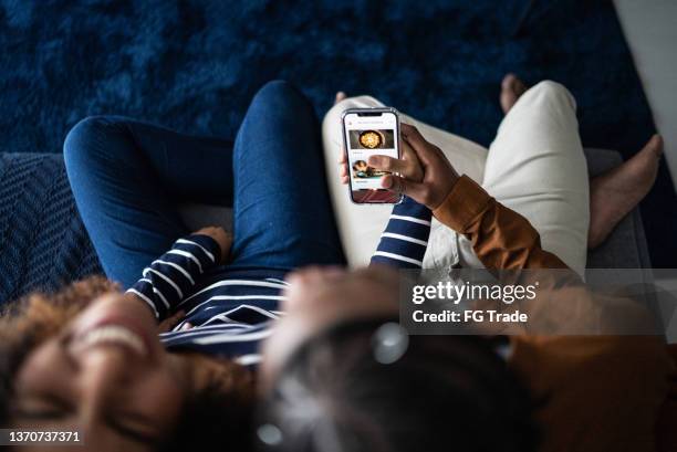 couple ordering food online with smartphone at home - delivery character stock pictures, royalty-free photos & images