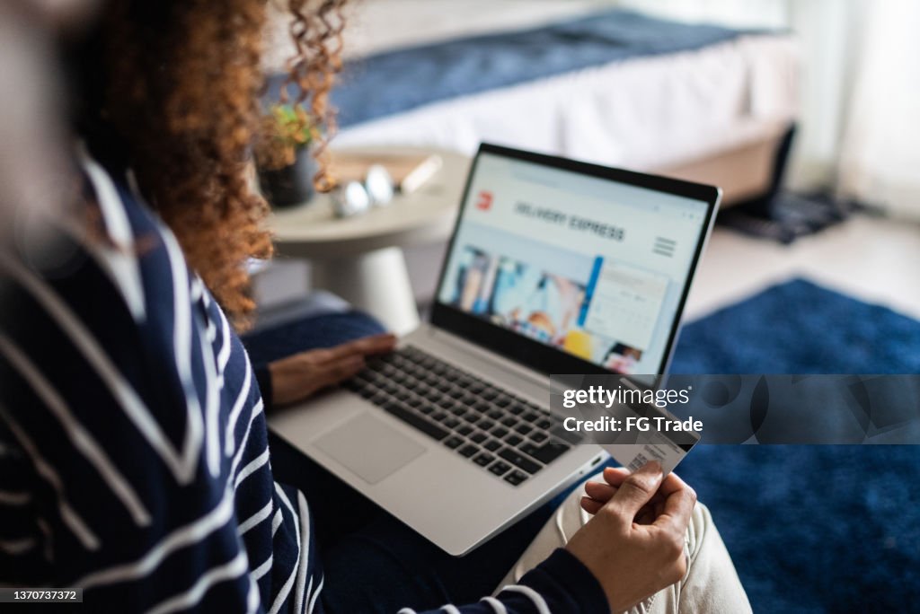 Young woman online shopping using the laptop at home