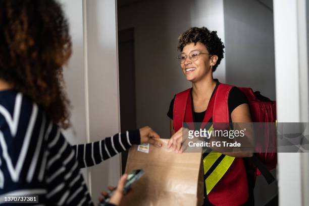 woman receiving delivery at home - take away food courier stock pictures, royalty-free photos & images