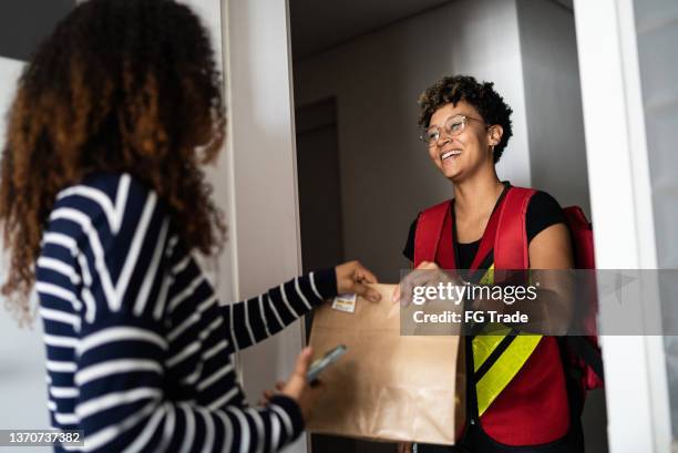 frau erhält lieferung zu hause - food delivery stock-fotos und bilder