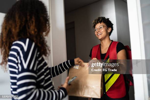 woman receiving delivery at home - food delivery stockfoto's en -beelden