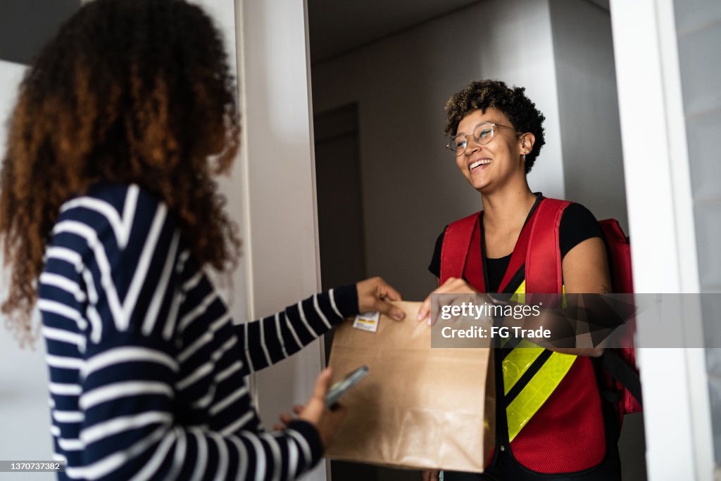 Mulher que recebe a entrega em casa