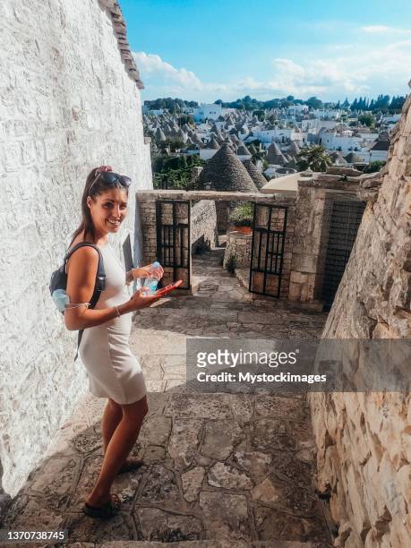 jeune femme explorant les maisons trulli dans le sud de l’italie - trulli photos et images de collection