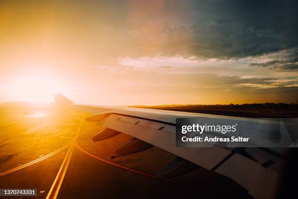 left wing of an airplane on the runway hitting evening sun - lax airport stock pictures, royalty-free photos & images