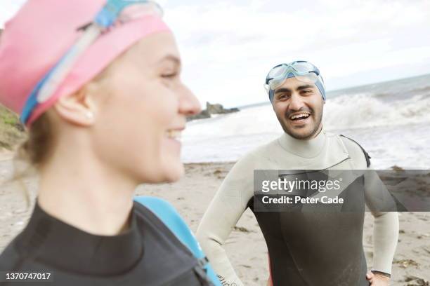 young man and woman in swimming gear looking at sea - extreme depth of field stock pictures, royalty-free photos & images