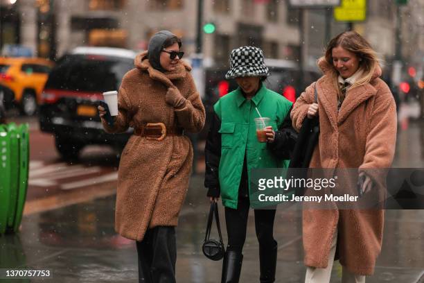 Fashion Week Guests wearing a brown fur coat and a green vest, black pants and beige pants and black boots outside Ulla Johnson, during New York...