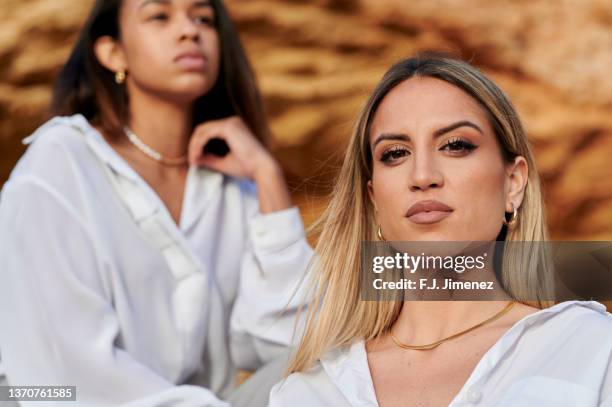 two elegantly dressed women posing on the rocks - lip liner stock pictures, royalty-free photos & images