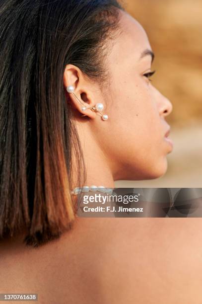 portrait of woman outdoors with earrings and necklace - black woman hair back stock pictures, royalty-free photos & images