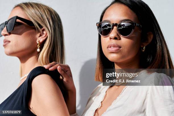 portrait of two women wearing sunglasses outdoors - luxury hair stock-fotos und bilder