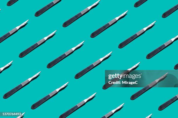 neatly arranged scalpels repetition pattern - scalpel stock pictures, royalty-free photos & images
