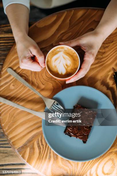 having a little break with a cup of latte and white chocolate brownie - tårta bildbanksfoton och bilder