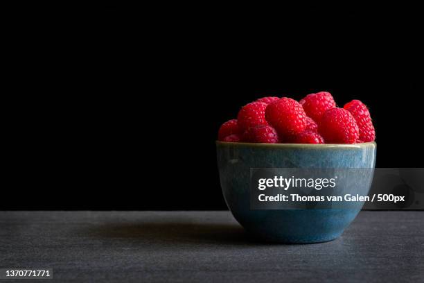 raspberries in a bowl,close-up of strawberry in bowl on table against black background,utrecht,netherlands - antioxidant bildbanksfoton och bilder
