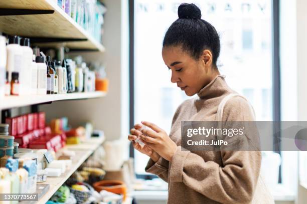 joven africana de compras en una tienda de cero residuos - perfumería fotografías e imágenes de stock