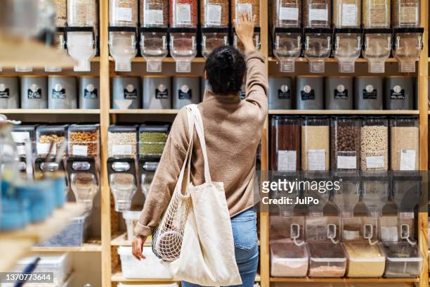 young african woman shopping in zero waste store - herbruikbare tas stockfoto's en -beelden