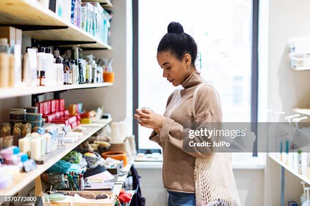 une jeune femme africaine fait ses courses dans un magasin zéro déchet - shampoo photos et images de collection