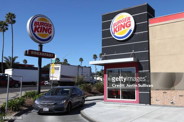 Car goes through the drive-thru a a Burger King restaurant on February 15, 2022 in Daly City, California. Restaurant Brands International, the parent...