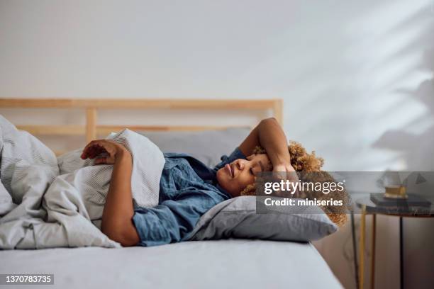 schöne frau macht ein nickerchen in ihrem schlafzimmer - woman taking a nap stock-fotos und bilder