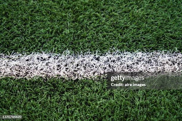 close up view of artificial turf with white markings delimiting a soccer field. - white turf stock-fotos und bilder