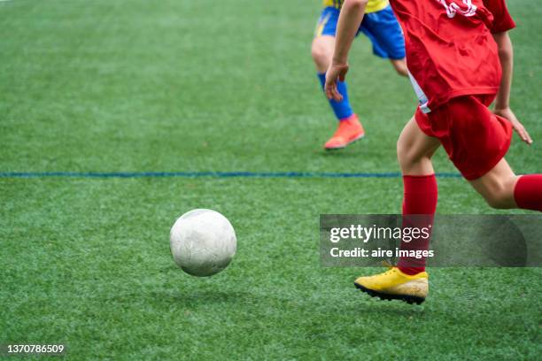 children playing on soccer field between little league teams, children running while the ball is in the air. - heading the ball stock pictures, royalty-free photos & images