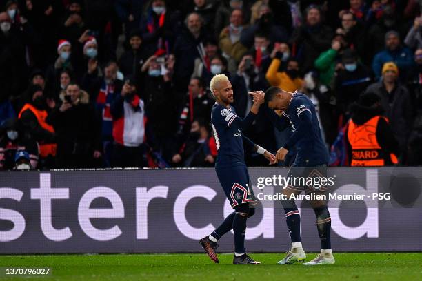 Kylian Mbappe of Paris Saint-Germain is congratulated by teammate Neymar Jr after scoring during the UEFA Champions League Round Of Sixteen Leg One...