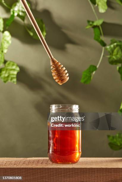 dripping honey to jar - honey jar stock pictures, royalty-free photos & images