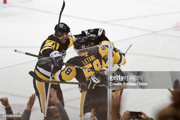 Evgeni Malkin and Kris Letang celebrate with Sidney Crosby of the Pittsburgh Penguins after Crosby scored his 500th NHL goal during the first period...