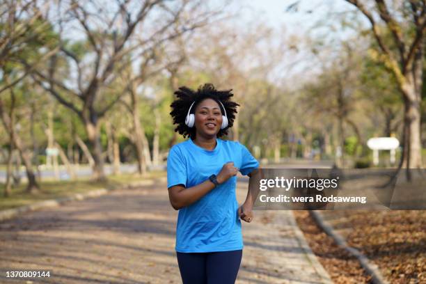 happy woman jogging exercise at park - woman headphones sport smile iphone stock pictures, royalty-free photos & images