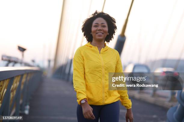 young woman walking exercise in city street - woman african sport stockfoto's en -beelden