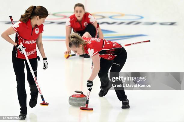 Dawn McEwen sweeps as Kaitlyn Lawes, left, and Jocelyn Peterman, back, of Team Canada look on against Team United States during the Women's Round...