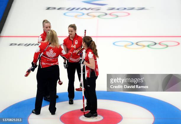Dawn McEwen, Jennifer Jones, Jocelyn Peterman and Kaitlyn Lawes of Team Canada celebrate a win against Team United States during the Women's Round...