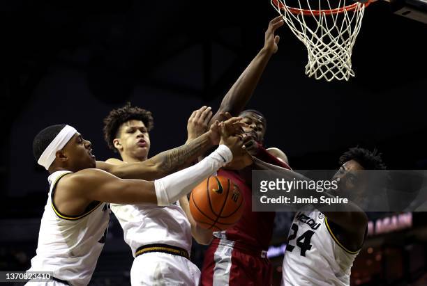 Trey Wade of the Arkansas Razorbacks competes with Jarron Coleman, Trevon Brazile and Kobe Brown of the Missouri Tigers for a rebound during the game...