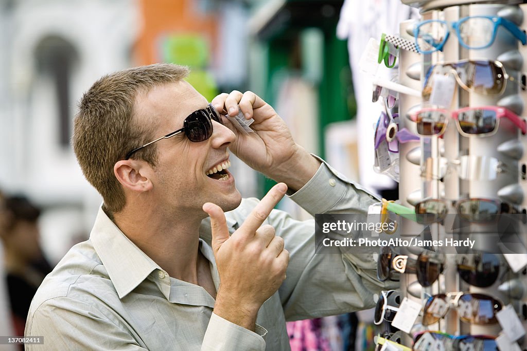 Man trying on sunglasses in street market