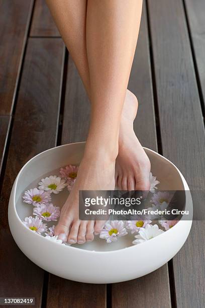 woman enjoying relaxing foot bath - female feet at spa stock-fotos und bilder
