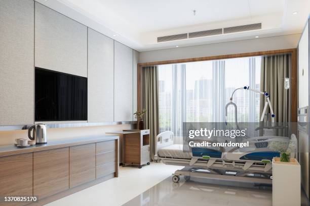 modern luxury hospital room interior with empty bed, lcd television and city view from the window - hospital quarantine stock pictures, royalty-free photos & images