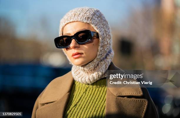 Guest is seen wearing knitted balaklava, olive green coat, Loewe sunglasses outside Peter Do during New York Fashion Week on February 15, 2022 in New...