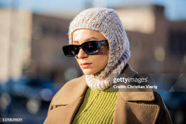 Guest is seen wearing knitted balaklava, olive green coat, Loewe sunglasses outside Peter Do during New York Fashion Week on February 15, 2022 in New...