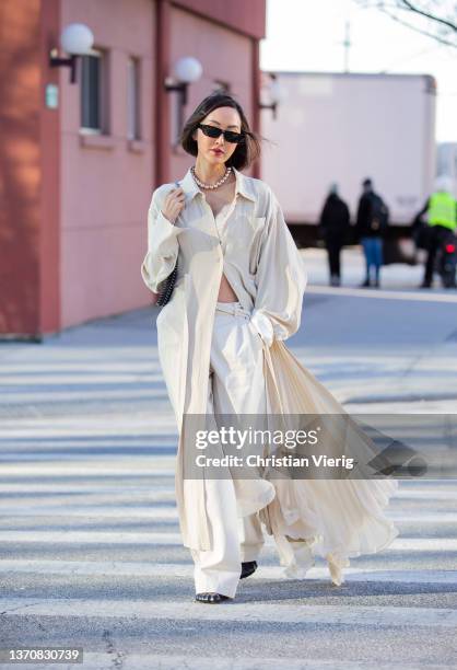 Chriselle Lim seen wearing button up dress in creme white, pants, cropped top, necklace, sunglasses, black bag outside Peter Do during New York...