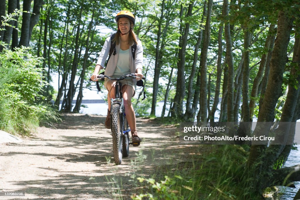 Woman riding bicycle in woods