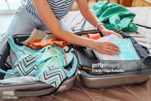 close up hands of unrecognisable woman packing suitcase. woman putting clothes inside of bag - carry on bag stock pictures, royalty-free photos & images