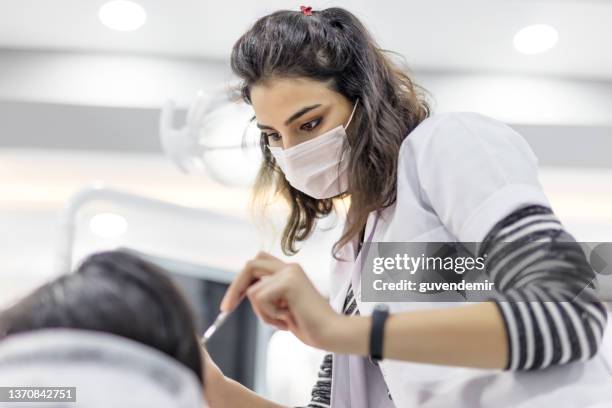 young female dentist doing dental examination - dental hygienist stock pictures, royalty-free photos & images