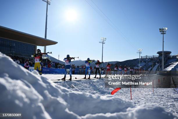 Athletes shoot from a standing position during the first leg of the Women's Biathlon 4x6km Relay on day 12 of 2022 Beijing Winter Olympics at...
