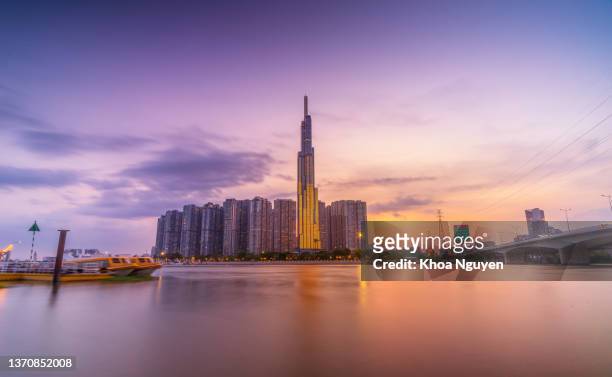 sunset view at landmark 81 - it is a super tall skyscraper and saigon bridge with development buildings along saigon river light smooth down. - saigon river stock pictures, royalty-free photos & images