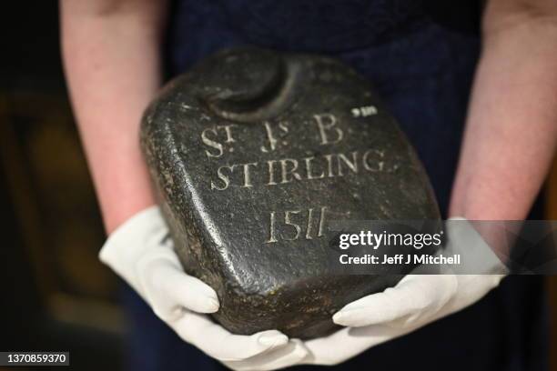 Nicola Wilson, Collection Manager at The Stirling Smith Art Gallery and Museum, holds a curling stone said to be the world's oldest, dating from 1511...