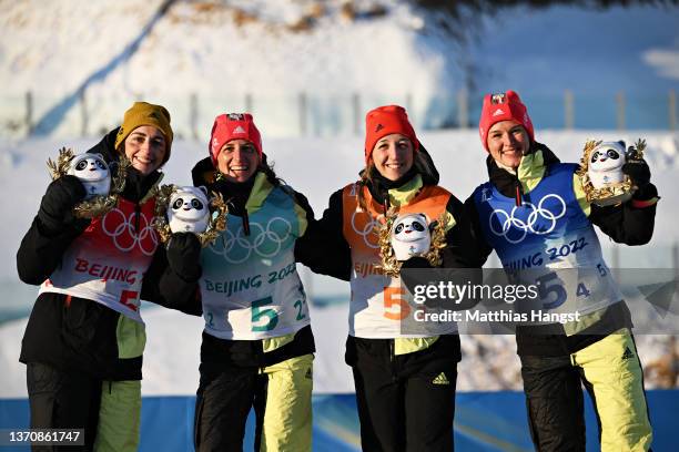 Bronze medallists Vanessa Voigt, Vanessa Hinz, Franziska Preuss and Denise Herrmann of Team Germany pose during Women's Biathlon 4x6km Relay flower...