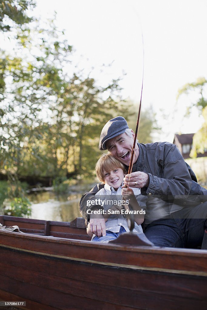 Grandfather and grandson fishing in boat